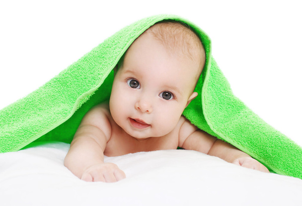 Closeup portrait of baby lying under green towel - Zdjęcie, obraz