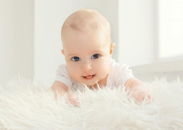 Closeup portrait of infant lying at home in white room near wind - Φωτογραφία, εικόνα