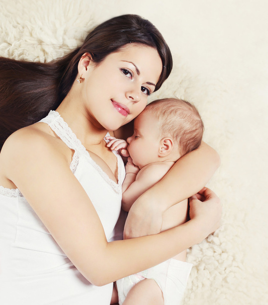 Retrato de madre joven con bebé durmiendo en la cama, vista superior
 - Foto, Imagen