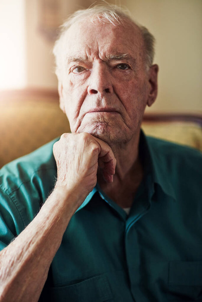 Nursing home, senior and portrait of man, thinking and memory in living room, patient and healthcare for elderly. House, lounge and wellness for Alzheimers, treatment and depression for retirement. - Fotoğraf, Görsel