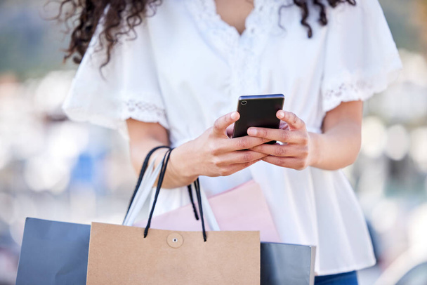 Woman, shopping and city or smartphone with hands, retail deal and customer with bags for online sale notification. Internet, tech and ecommerce app, texting and black friday offer or buying special. - Photo, Image