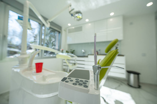 Stomatological instrument in dentists clinic. Dentist tools attached to a dental chair. - Photo, Image