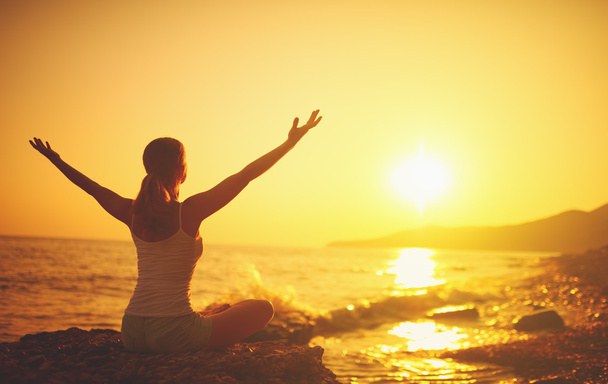 ioga ao pôr do sol na praia. mulher fazendo ioga
 - Foto, Imagem