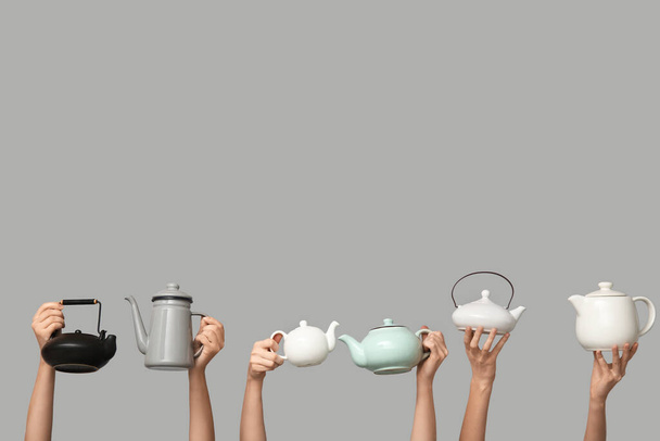 Жінки з чайниками на сірому фоні - Фото, зображення