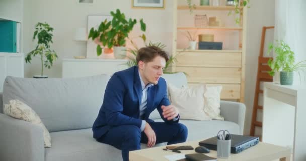 Surullinen masentunut liikemies istuu sohvalla - Materiaali, video