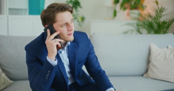 Zakenman in gesprek op een mobiele telefoon met een aannemer - Video