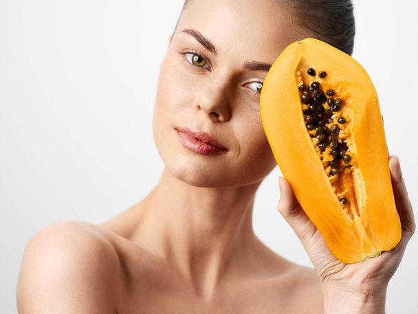 Gyönyörű fiatal nő papaya gyümölcs arc maszk elszigetelt fehér háttér, bőrápolás és szépség koncepció - Fotó, kép