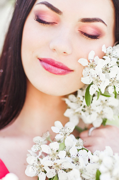 Retrato de mujer joven y encantadora en flores de primavera
 - Foto, Imagen