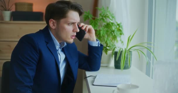 Triste uomo d'affari che parla al telefono mentre lavora - Filmati, video
