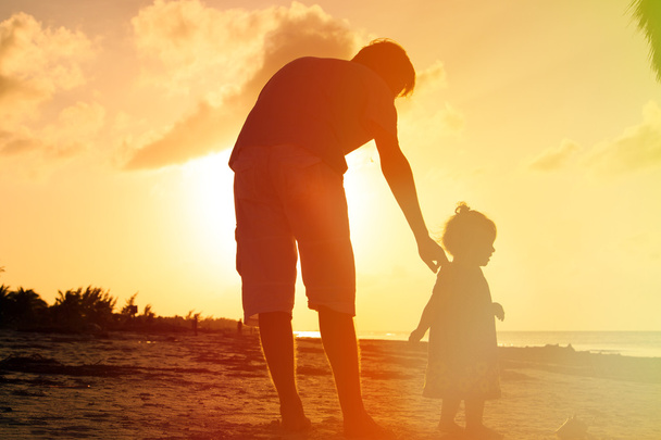 πατέρας και μικρή κόρη περπατούν στην παραλία το ηλιοβασίλεμα - Φωτογραφία, εικόνα