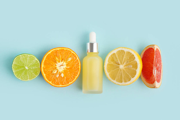 Összetétel egy üveg illóolaj és a különböző citrusfélék színes háttér - Fotó, kép