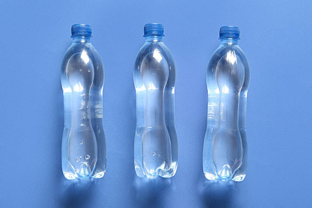 пластиковые бутылки воды на синем фоне
 - Фото, изображение