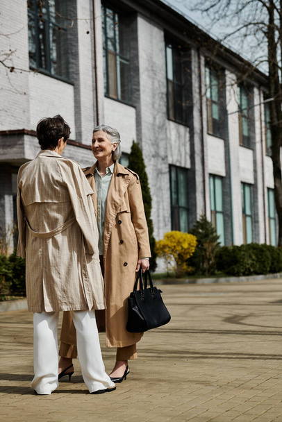 A mature, beautiful lesbian couple standing elegantly in front of a grand building. - Photo, Image