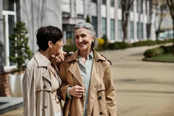 Ältere lesbische Paare unterhalten sich, während sie ins Büro gehen. - Foto, Bild