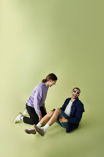 Dos hombres sentados en el suelo, disfrutando de la compañía del otro. - Foto, Imagen