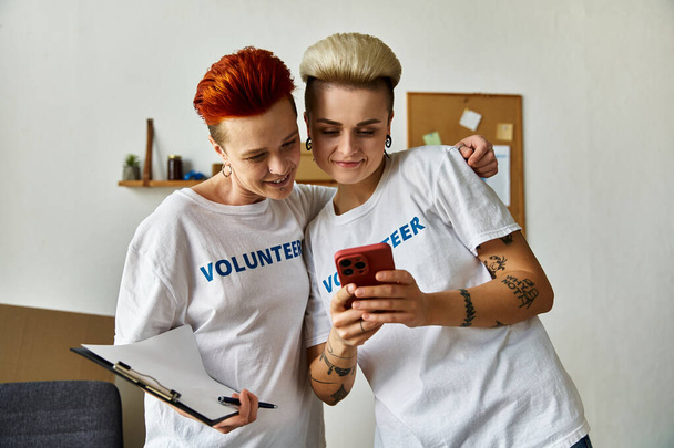 Vapaaehtoisilla t-paidoilla puettu lesbopari liittyi hyväntekeväisyystyöhön.. - Valokuva, kuva