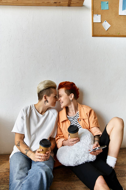 Młoda lesbijska para robi sobie przerwę na drewnianej ławce w centrum wolontariatu otoczona pudłami. - Zdjęcie, obraz