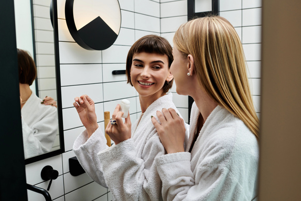 A young woman in a bath robe stands before a mirror, methodically flossing her teeth in a hotel bathroom. - Photo, Image