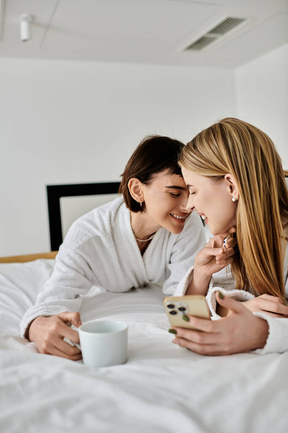 Twee vrouwen in badjassen lagen vredig naast elkaar op een luxueus hotelbed, een teder moment van nabijheid en verbinding delend. - Foto, afbeelding