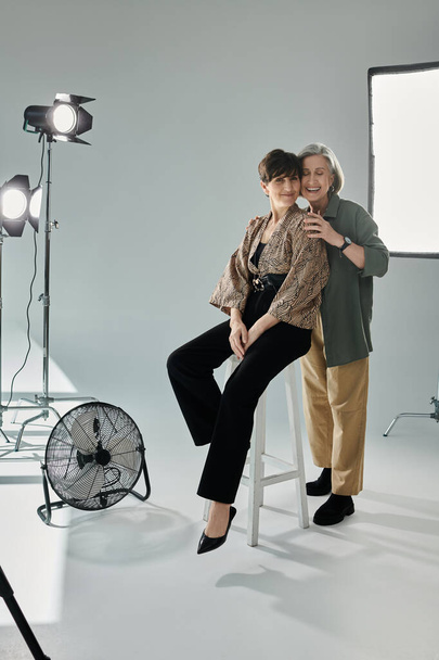 Una mujer de mediana edad con estilo para una sesión de fotos, un abrazo sincero de pareja lesbiana - Foto, Imagen