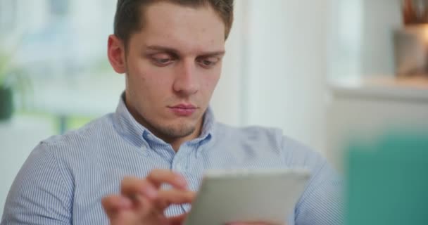 El hombre trabaja en una tableta digital y hace compras en línea - Metraje, vídeo