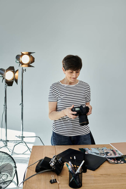 Μια γυναίκα ρυθμίζοντας τις ρυθμίσεις σε μια κάμερα για μια επαγγελματική φωτογράφηση. - Φωτογραφία, εικόνα