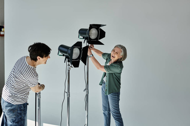 middle-aged lesbian couple, pose confidently in a modern photo studio. - Photo, Image