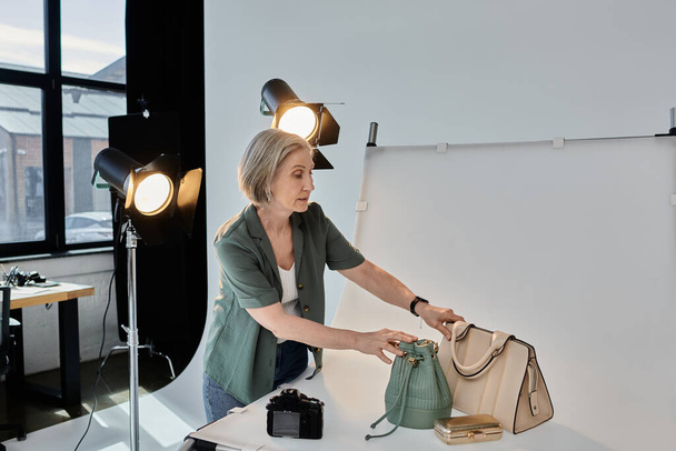 Um fotógrafo segura com confiança uma bolsa na frente de uma câmera em um estúdio de fotos moderno profissional. - Foto, Imagem
