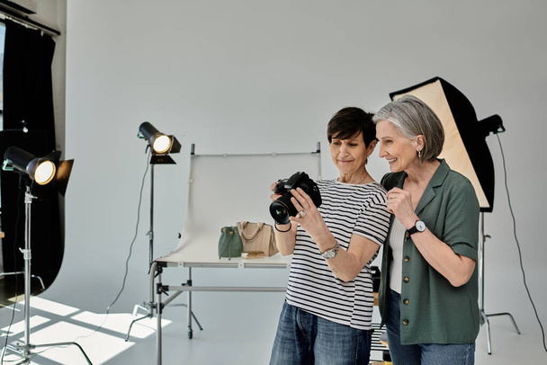 Fotoğraf stüdyosundaki bir kadın fotoğraf makinesi kullanırken fotoğraf çekiyor, ortak ve yaratıcı bir ortamda.. - Fotoğraf, Görsel