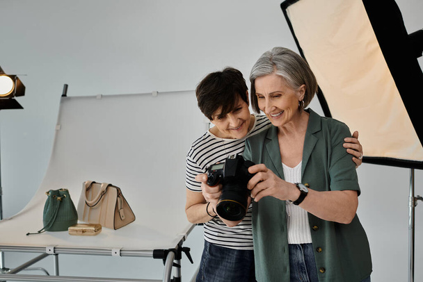 Donna in uno studio fotografico, con una macchina fotografica in mano, sorridente. - Foto, immagini