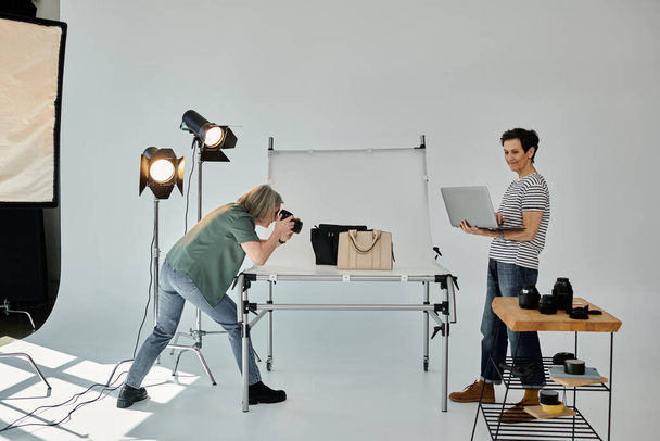 A middle-aged woman captures bags in a professional photo studio setting. - Photo, Image