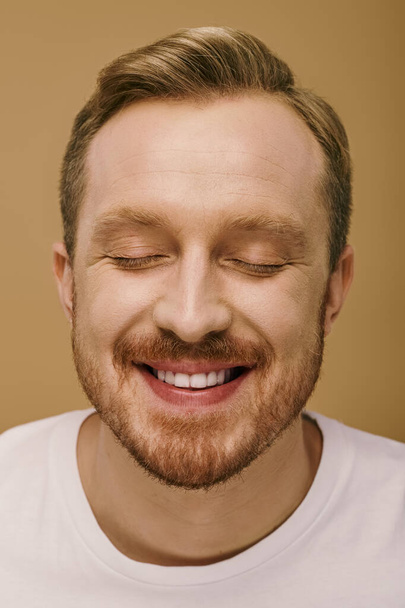 Άνδρας με κομψή ενδυμασία, μάτια κλειστά, χαμογελαστός ακτινοβόλα. - Φωτογραφία, εικόνα