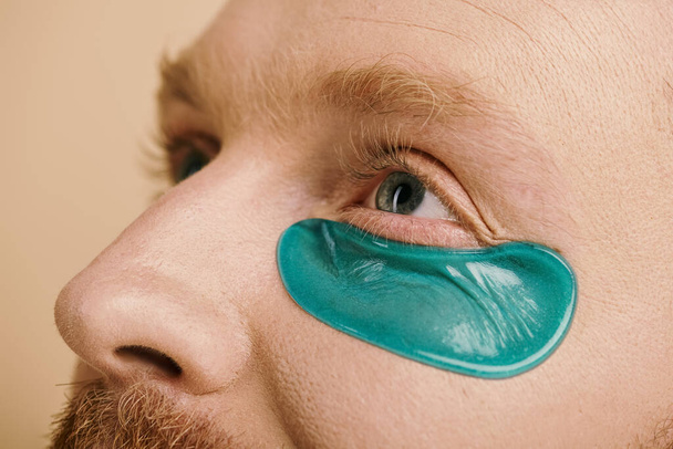 Een stijlvolle man met levendige blauwe ooglapjes op zijn gezicht. - Foto, afbeelding