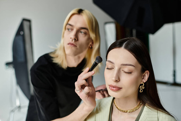 Επαγγελματική makeup artist εφαρμόζει μακιγιάζ σε ένα γυναικείο πρόσωπο, ενισχύοντας την ομορφιά της. - Φωτογραφία, εικόνα