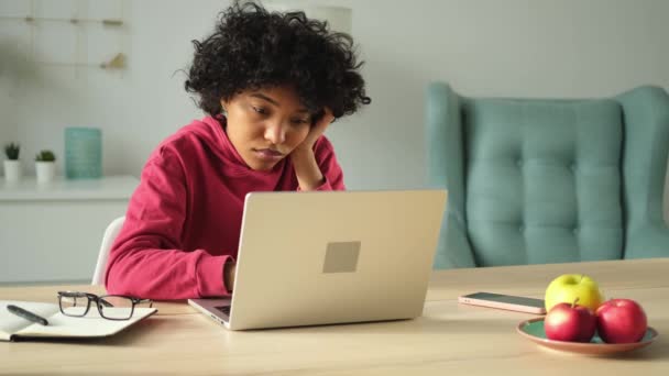 Африканська дівчина-американка використовує ноутбук у себе вдома, спостерігаючи за розмовною розмовною розмовою на екрані з письмовою поштою. Молода жінка проводить віртуальну конференцію онлайн-дзвінків. Навчайся вдома - Кадри, відео