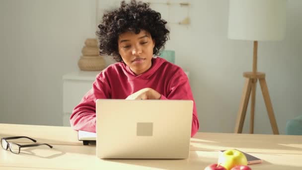 Африканская американка, использующая ноутбук, ведет видео-чат дома. Молодая женщина проводит виртуальную встречу онлайн чат видео-конференции. Обучение работе на дому, дистанционный учитель - Кадры, видео