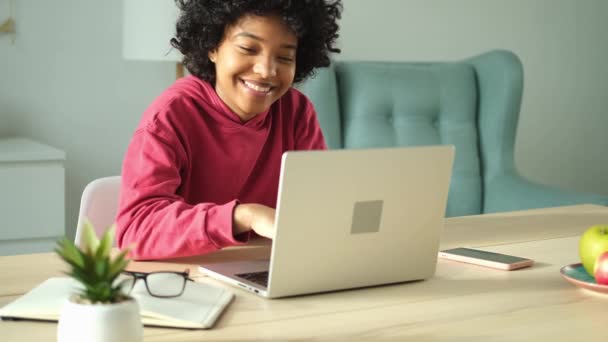 African american girl using laptop at home office looking at screen typing chatting reading writing email. Young woman having virtual meeting online chat video call conference. Work learning from home - 映像、動画