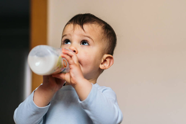 söpö vauva tilalla ja juominen maitoa pullo - Valokuva, kuva