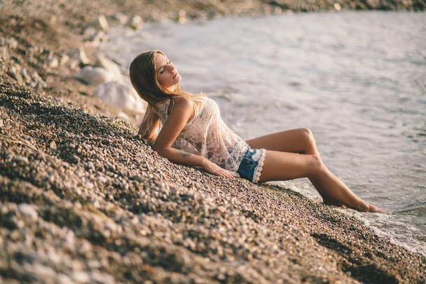 verträumte Mädchen entspannen am Strand in modischen Jeanshemden - Foto, Bild