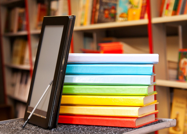 Empilement de livres colorés avec lecteur de livres électroniques
 - Photo, image