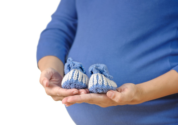 Έγκυος γυναίκα που κρατάει παιδικά μποτάκια - Φωτογραφία, εικόνα