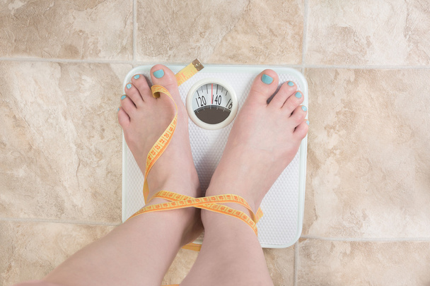 Woman standing on a weight scale - Photo, Image