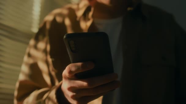 Тонкие кадры молодого кудрявого мужчины, читающего сообщение на смартфоне, выглядящего обеспокоенным, не знающего, что делать, и осознающего безнадежность и отчаяние ситуации - Кадры, видео