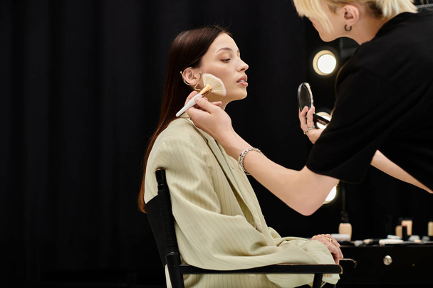 Make-up kunstenaar het aanbrengen van make-up op een vrouw gezicht. - Foto, afbeelding