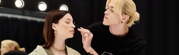 A man applying makeup on womans face. - Photo, Image