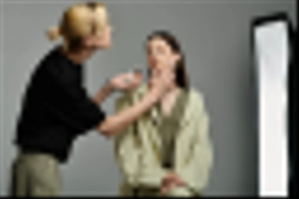 Een make-up kunstenaar verfraait een klant. - Foto, afbeelding