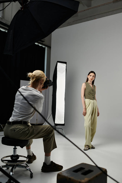 Frau posiert vor der Kamera während eines Fotoshootings mit einem Fotografen. - Foto, Bild