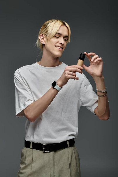 happy blonde man holding highlighter and smiling on grey background - Photo, Image