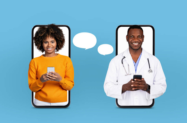 Afroamerikanische Ärztin und eine Frau unterhalten sich, halten Smartphones an die Ohren. Sie wirken fokussiert und bestrebt auf die Diskussion. - Foto, Bild