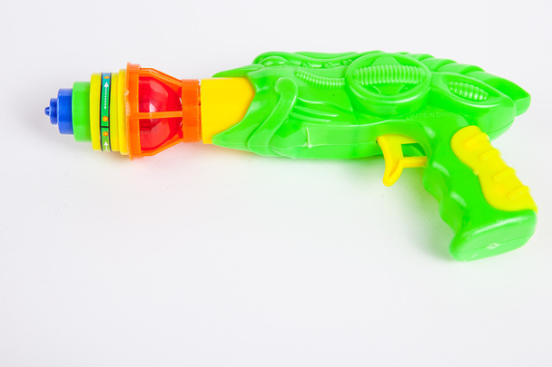toy gun with spinning top on white paper background  - Foto, Imagem